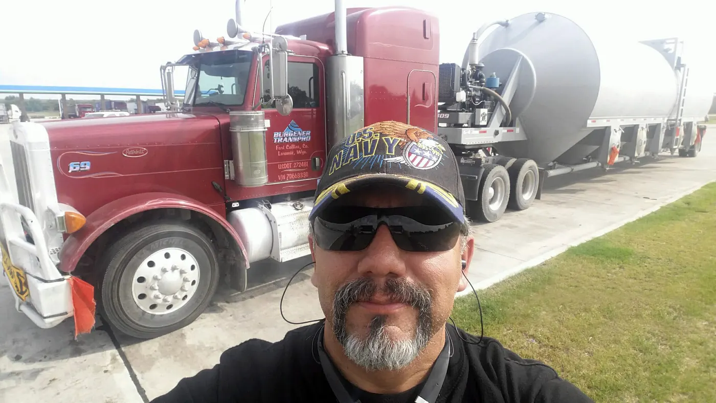 TransPro driver in sunglasses and a cap in front of his truck